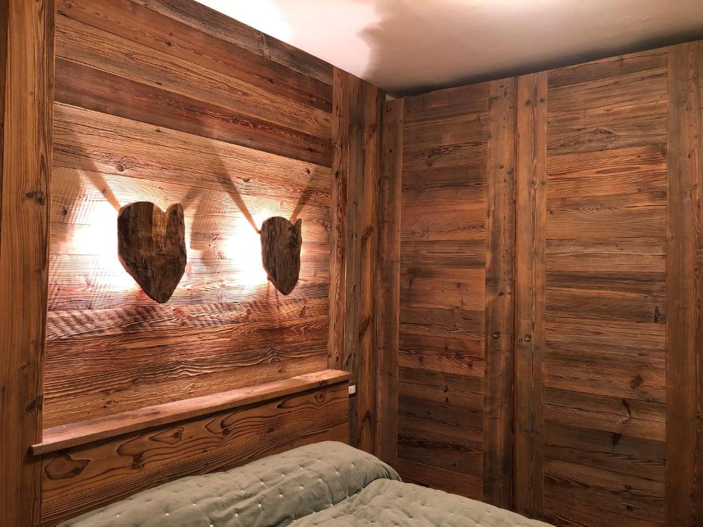 - une chambre avec des murs en bois et un lit dans un dortoir dans l'établissement Splendido trilocale direttamente sulle piste - sanificato dopo ogni soggiorno, à Aprica