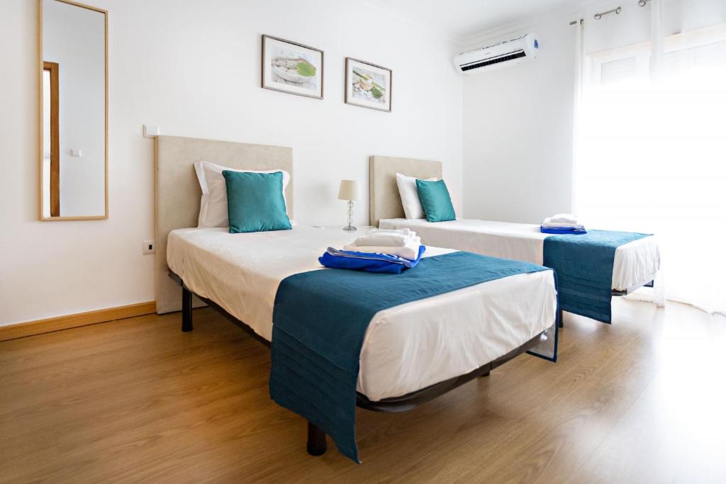 2 Betten in einem blau-weißen Zimmer in der Unterkunft Gardénia Apartment in Santa Luzia