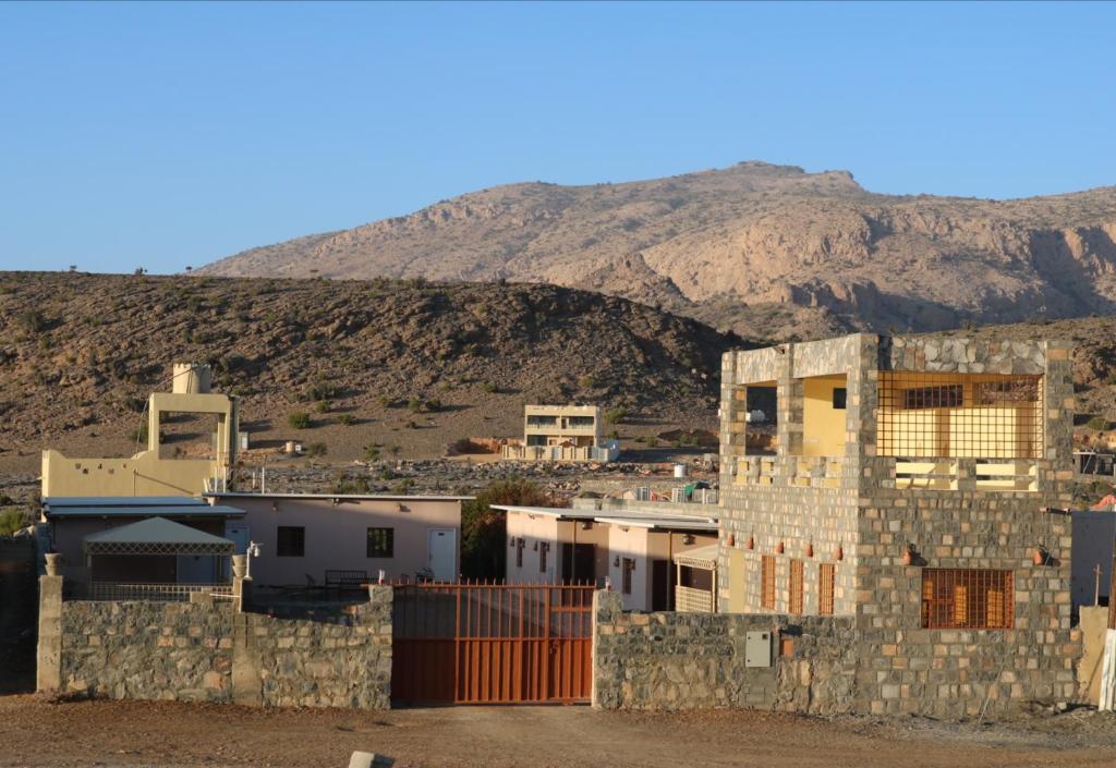a group of buildings in front of a mountain at Jabel shams stars house in Al Ḩamrāʼ