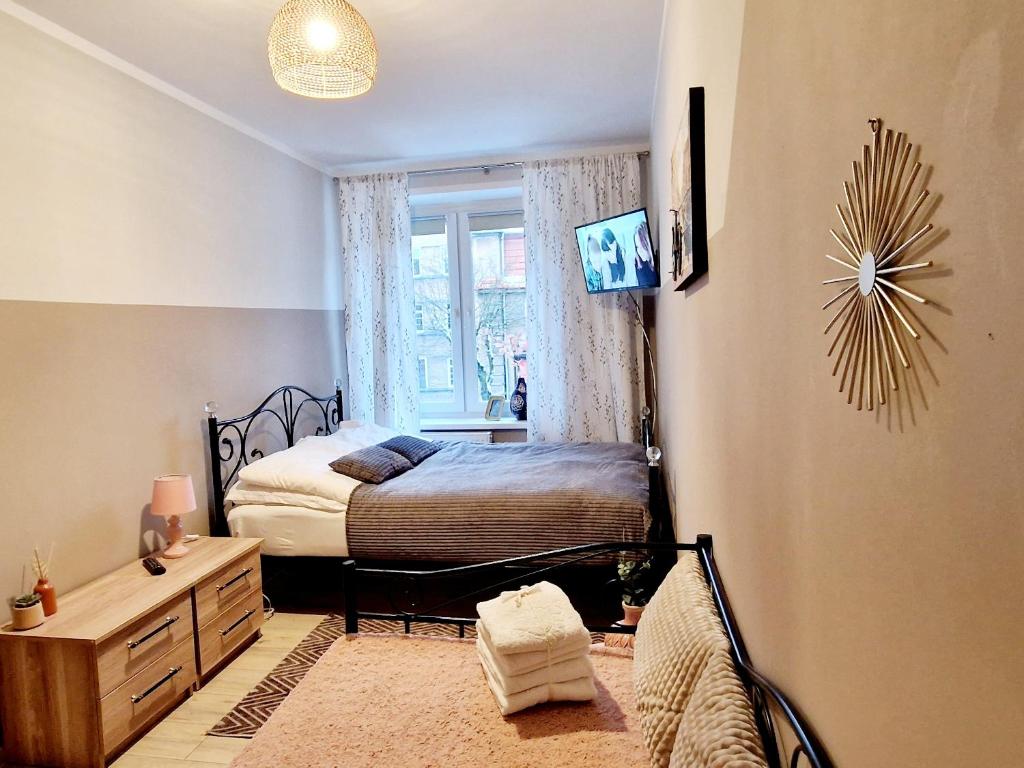 a small bedroom with a bed and a window at Old Town Room Ełk in Ełk