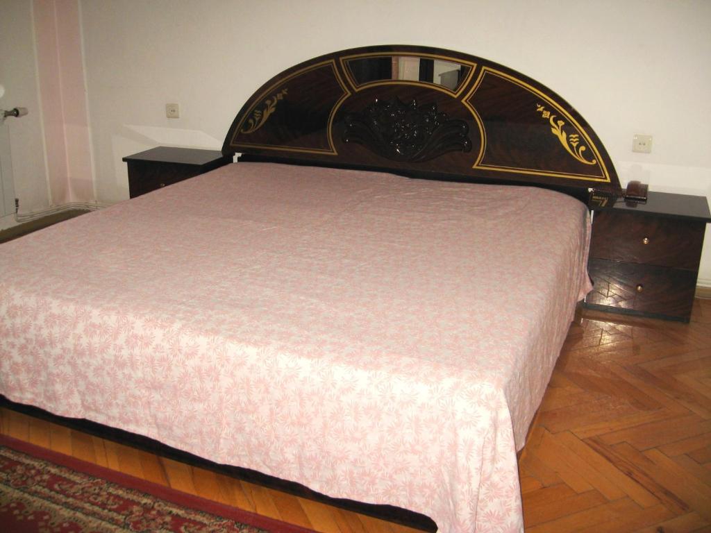 Cama en habitación con suelo de madera en Apartment on Tumanyan, en Ereván