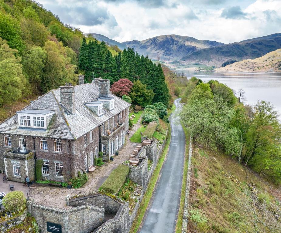 eine Luftansicht eines großen Hauses auf einem Hügel neben einem Fluss in der Unterkunft Haweswater Hotel in Bampton