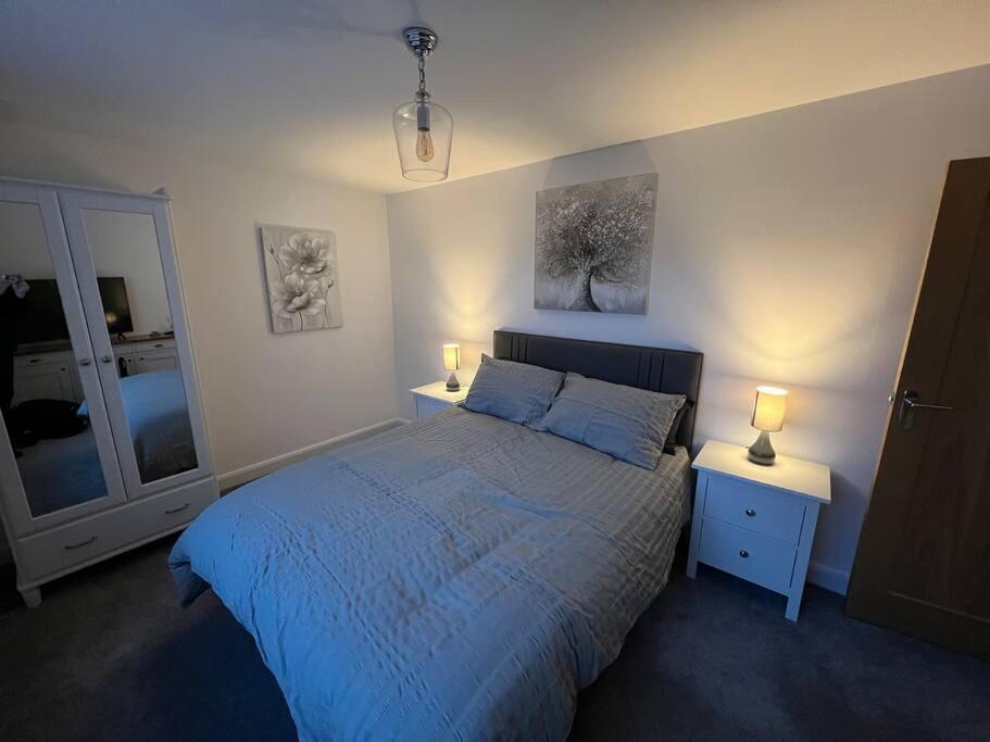 The Hideaway Southport في ساوثبورت: غرفة نوم مع سرير مع مواقف ليلتين ومصباحين