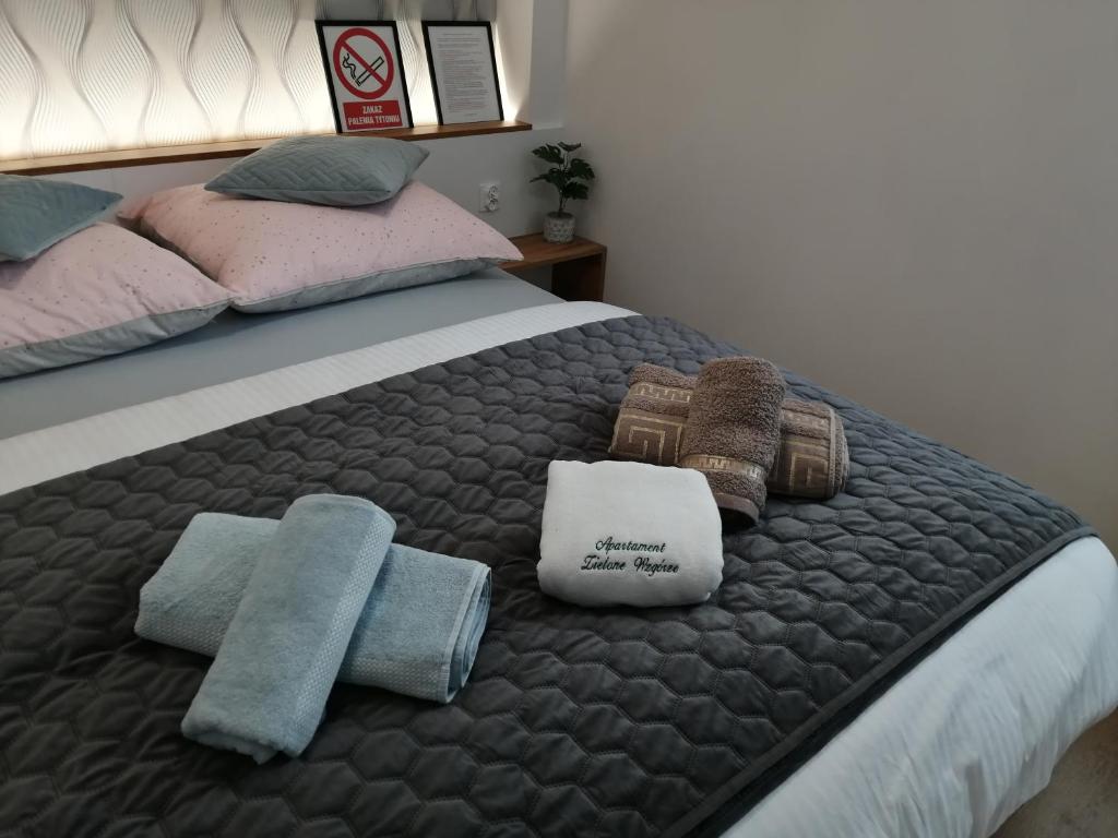 łóżko z ręcznikami i poduszkami w obiekcie Apartament Zielone Wzgórze 2 w Jeleniej Górze