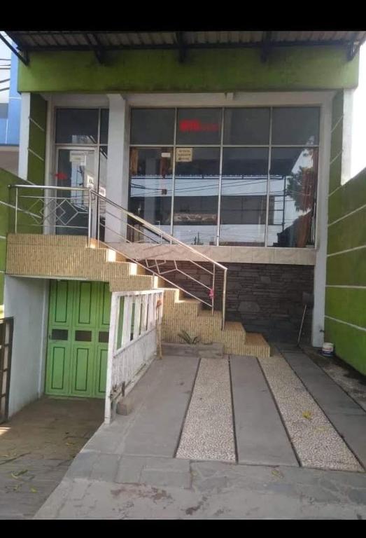 un edificio verde con una puerta verde y una escalera en Hotel Griya Syar'i, en Pekalongan