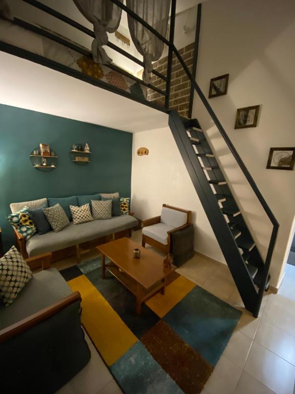 a living room with a couch and a staircase at Small cosy house Lavrion in Lávrion