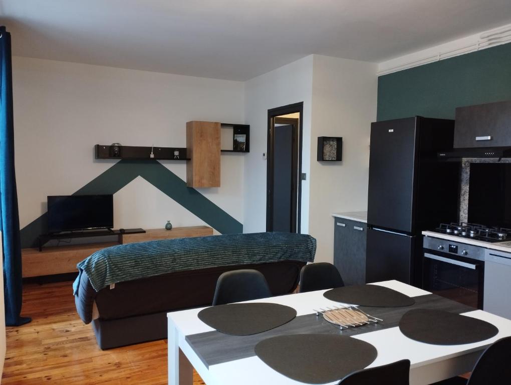 a bedroom with a bed and a kitchen with a table at Appartement moderne in Le Puy en Velay