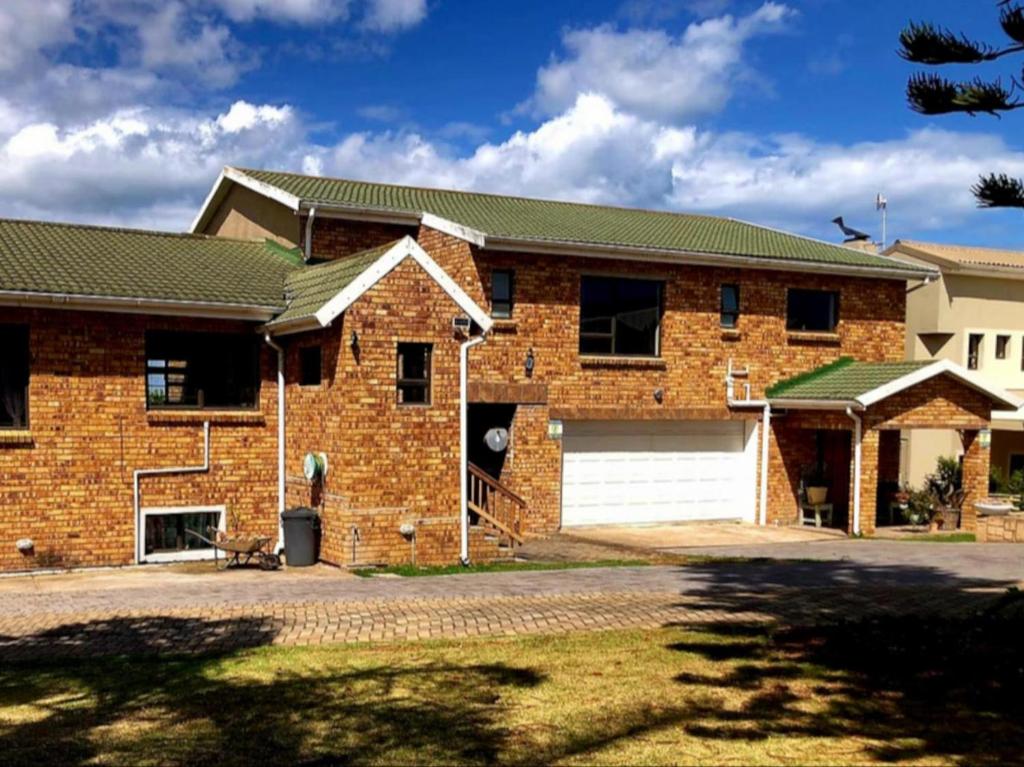 a brick house with a garage at Tiny's Getaway in Jeffreys Bay