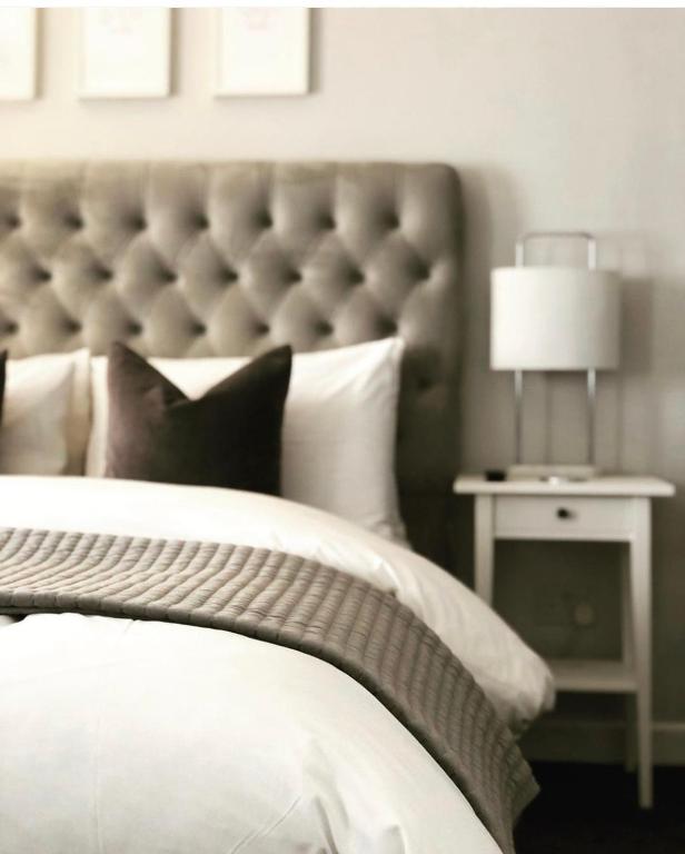 a bedroom with a white bed with a large headboard at Chadberry House Hotel in Blackpool