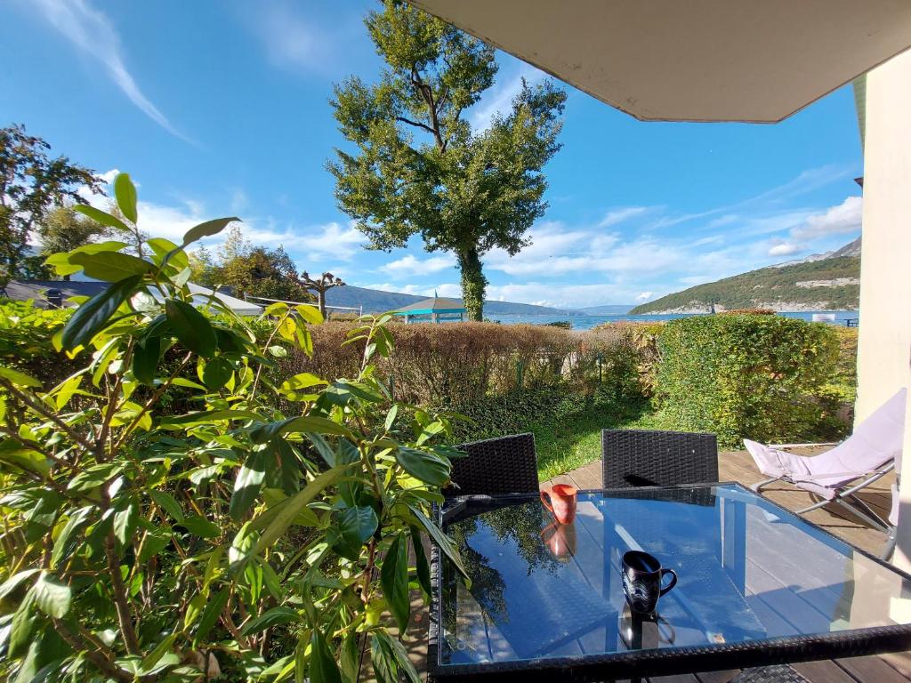 a glass table with two laptops on top of it at Studio les Pieds dans L'eau au bord du lac d'Annecy in Duingt