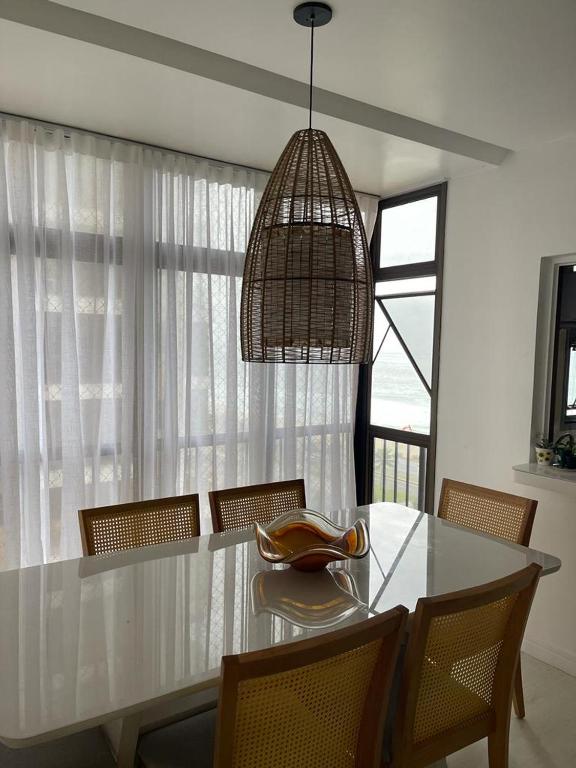 Hotel Apart Barra da Tijuca, a dining room table with chairs and a chandelier at Apart Barra da Tijuca in Rio de Janeiro