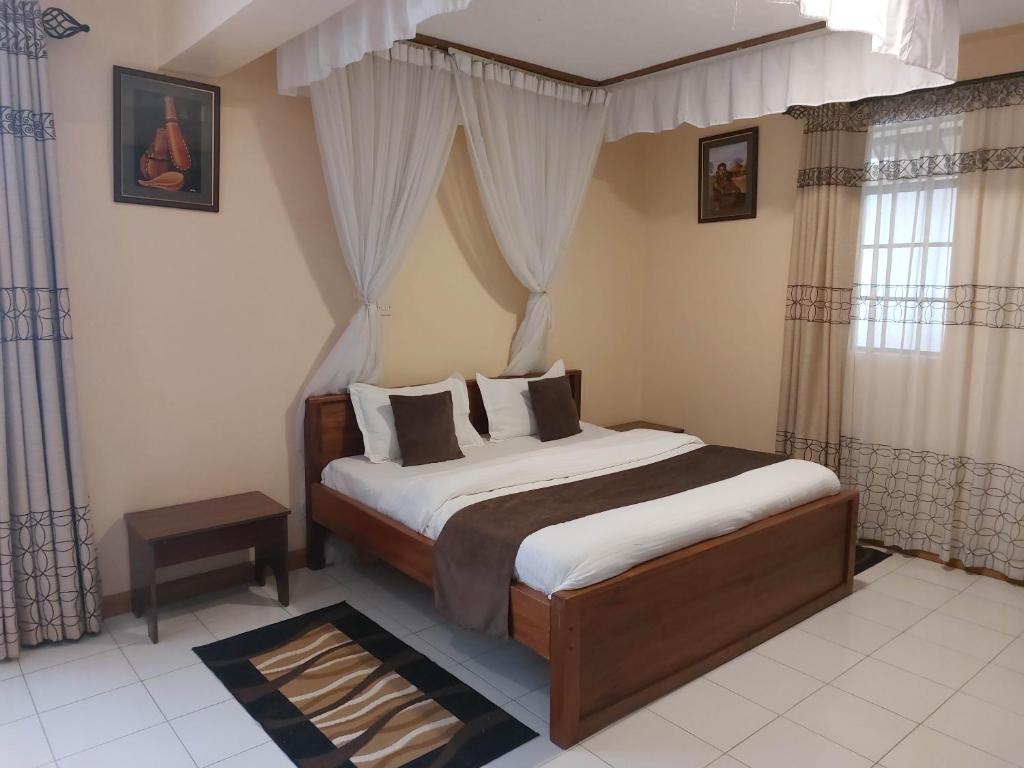 a bedroom with a large bed with a canopy at Roza Guest House in Naivasha