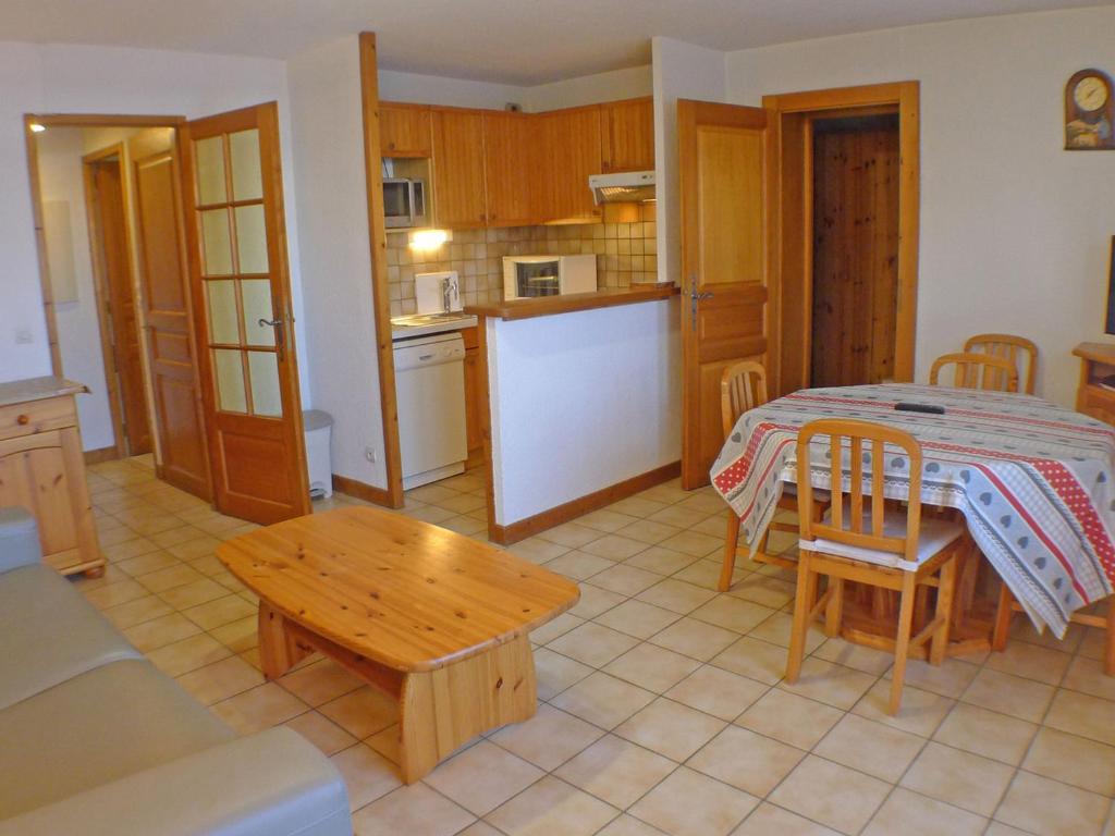 ein Wohnzimmer mit einem Tisch und einer Küche in der Unterkunft Appartement Samoëns, 2 pièces, 4 personnes - FR-1-629-72 in Samoëns