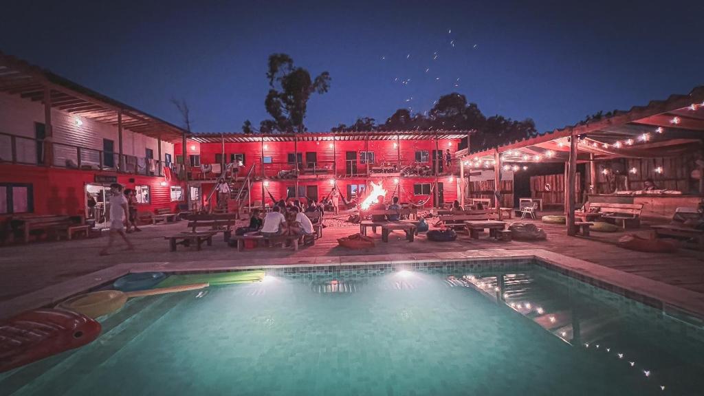 - une piscine en face d'un bâtiment la nuit dans l'établissement Compay Hostel La Pedrera, à La Pedrera