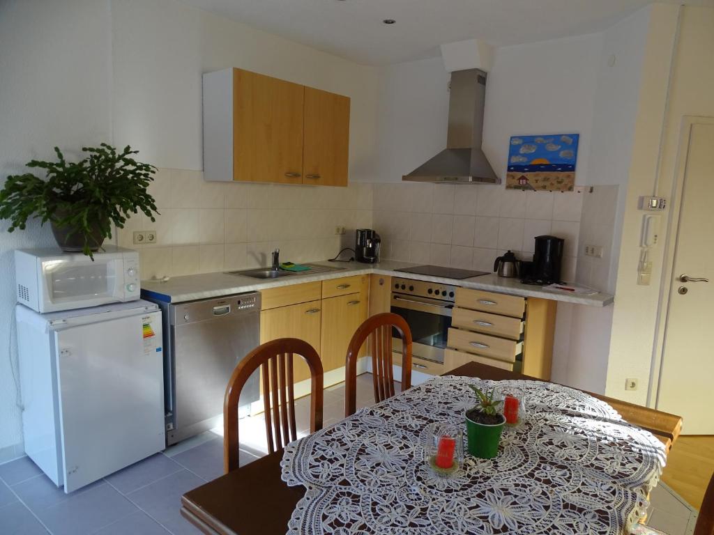 une cuisine avec une table et un réfrigérateur blanc dans l'établissement Ferienwohnung Lottstetten, à Lottstetten