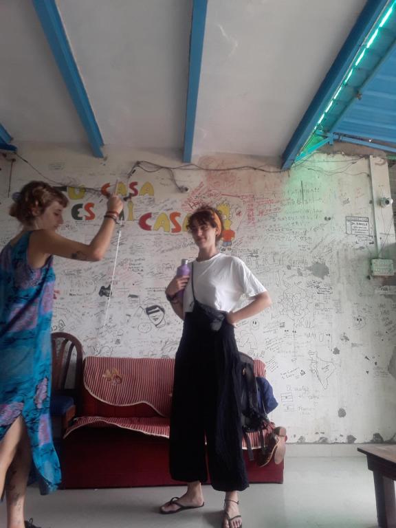 two women are painting a wall in a room at Superinn home stay& guest house in Agra