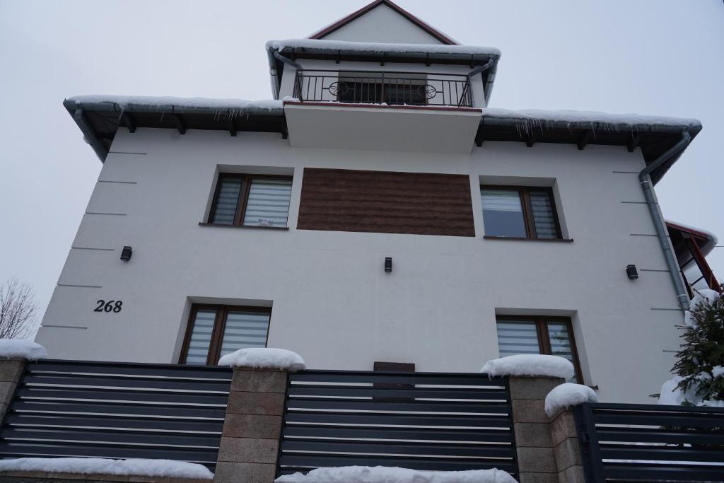 un edificio con nieve en las escaleras delante en DOM NA SKARPIE, en Mszana Górna