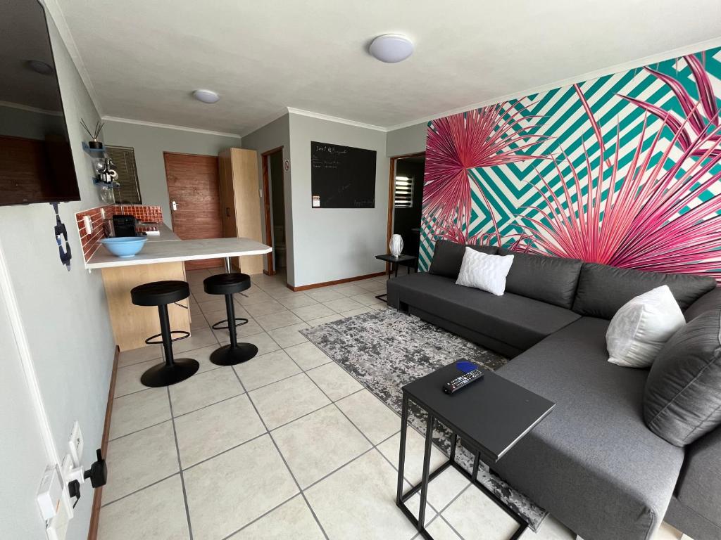 a living room with a couch and a kitchen at 1One1@Boneyard in Jeffreys Bay