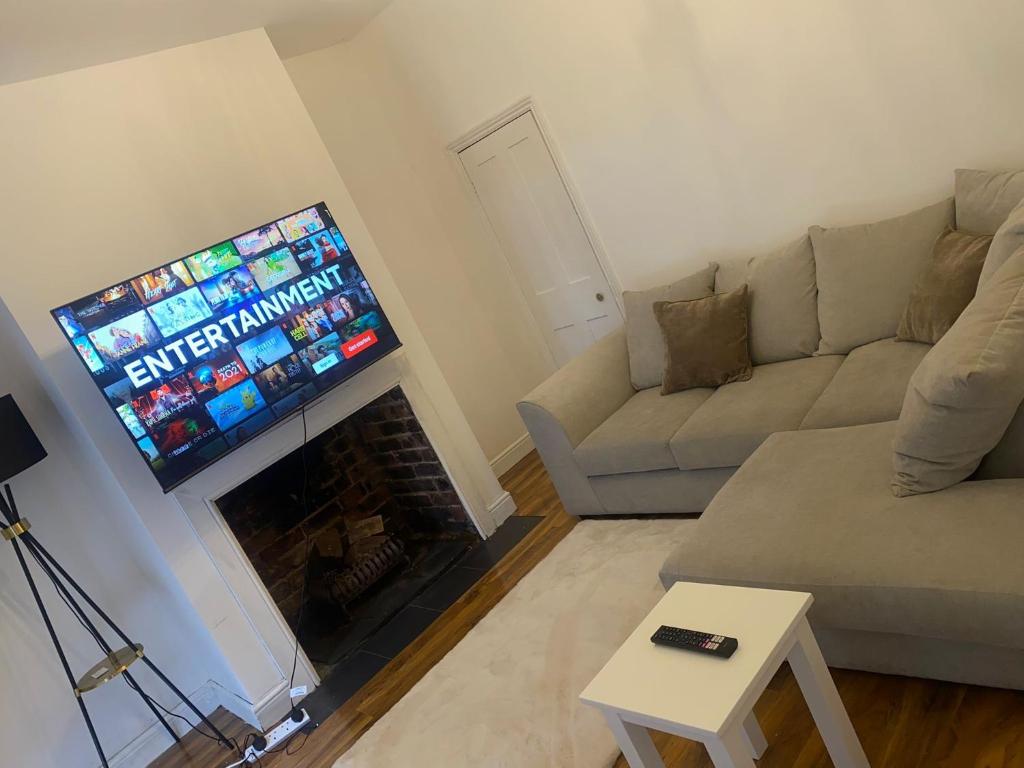 a living room with a couch and a flat screen tv at Relaxing Crewe home in Crewe