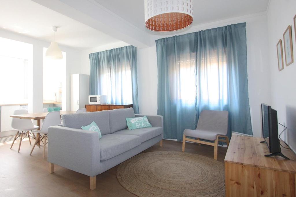 uma sala de estar com um sofá e uma televisão em Apartment Jara, Tavira em Tavira
