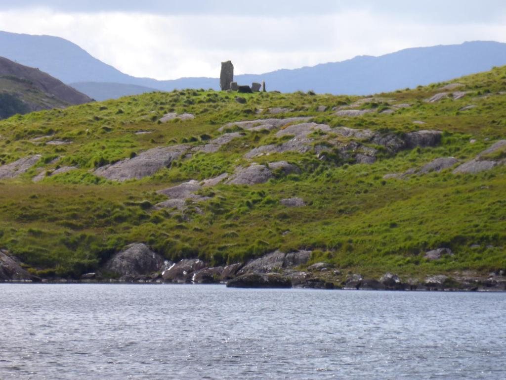 a hill with a monument on it next to a body of water at Oakfield in Kenmare