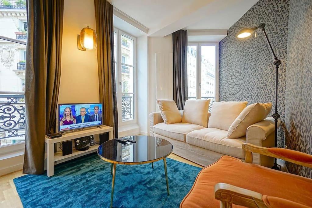 un salon avec un canapé et une table dans l'établissement Elegant appartement dans le Marais - Paris 3, à Paris