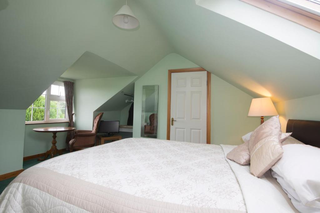 a bedroom with a white bed in a attic at Oakfield in Kenmare