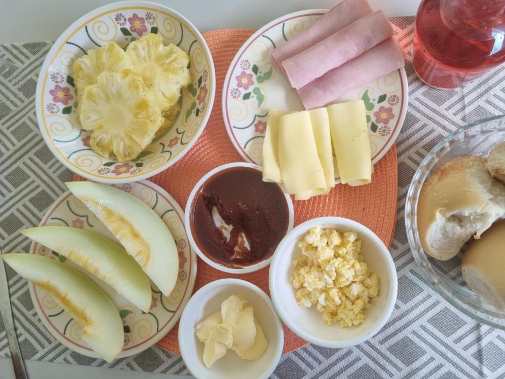 a table with plates of food with fruit and other foods at La casa de Luna in Guaibim