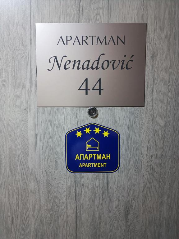 a sign for the american neanderthal actowment on a wooden door at Nenadovic Apartman in Obrenovac