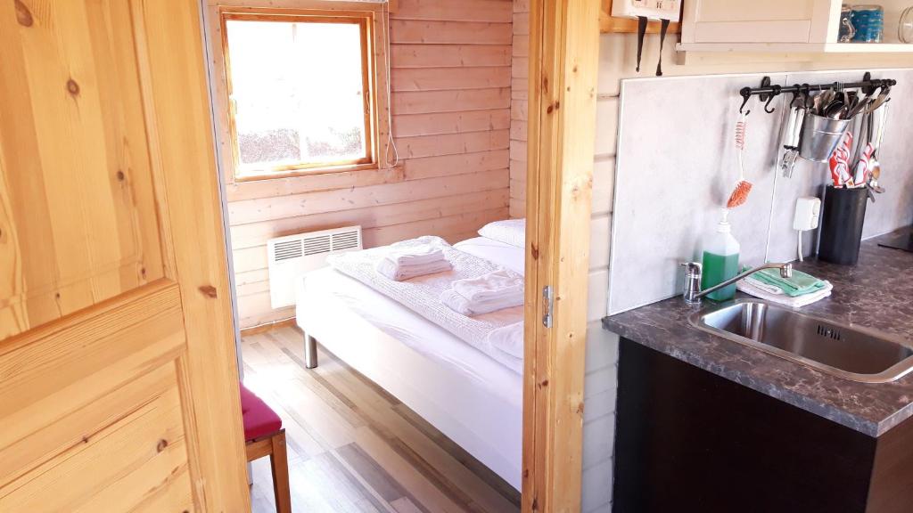 Una cocina con fregadero y una cama en una habitación. en Stundarfriður cottages, en Stykkishólmur