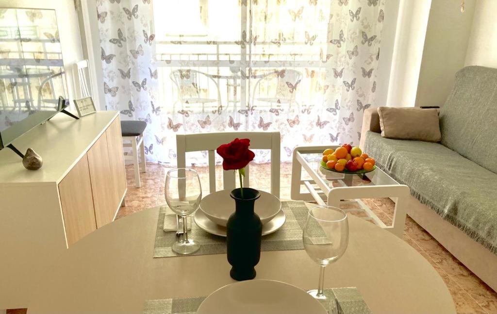 een woonkamer met een tafel met een roos erop bij DE VACACIONES in Torrevieja