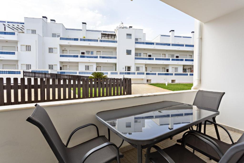 un balcón con mesa y sillas y un edificio en Lavender Apartment en Santa Luzia