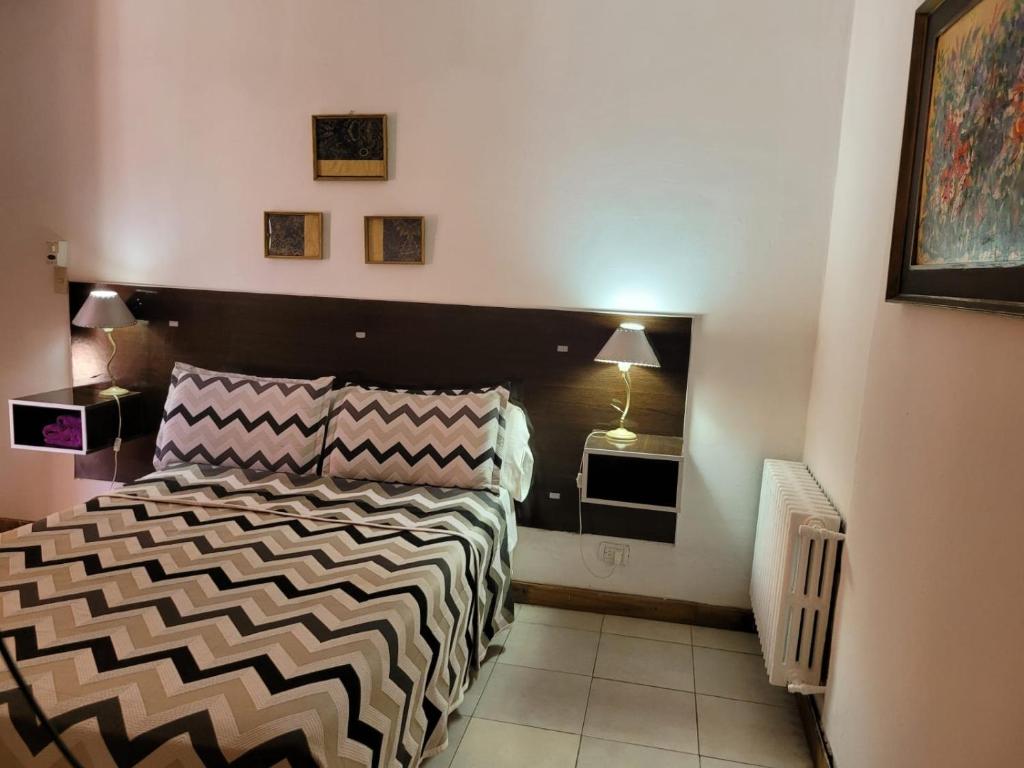 a bedroom with a bed with a black and white comforter at Cerro Uritorco Hotel in Capilla del Monte