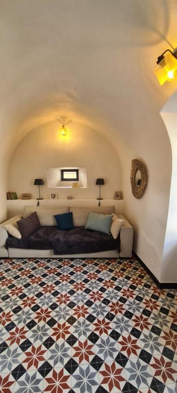 a living room with a bed and a tiled floor at Magnifique maison en coeur de Balazuc, proche plages ardèche in Balazuc