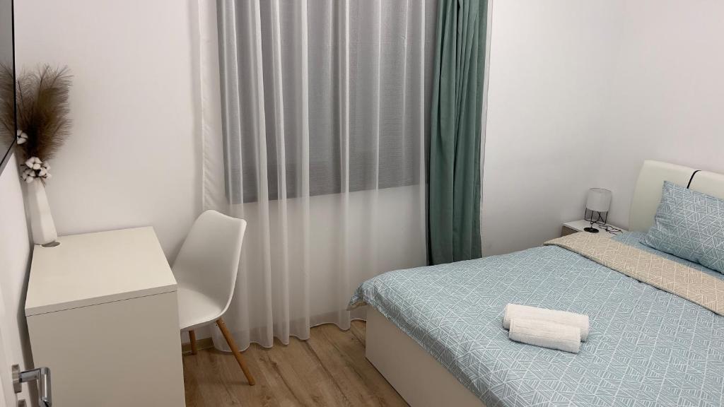 a small bedroom with a bed and a desk at Nathallie Modern Apartments in Timişoara