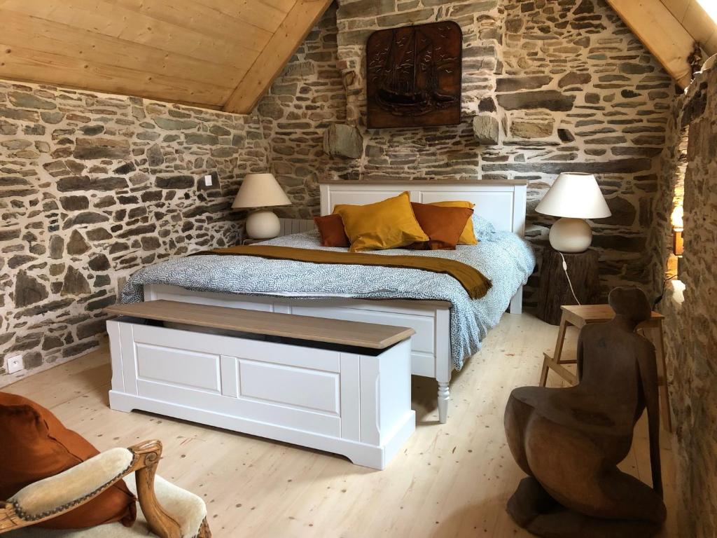 um quarto com uma cama e uma parede de pedra em Au cœur du quartier historique em Lannion