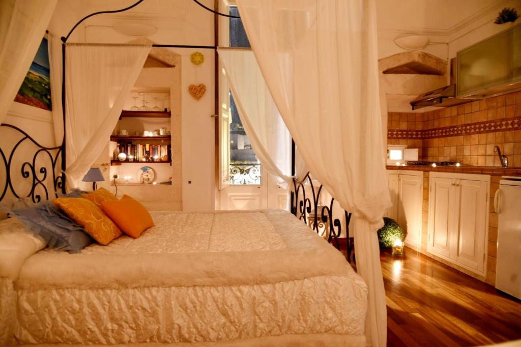 a bedroom with a canopy bed with orange pillows at Il Pregio in Ostuni