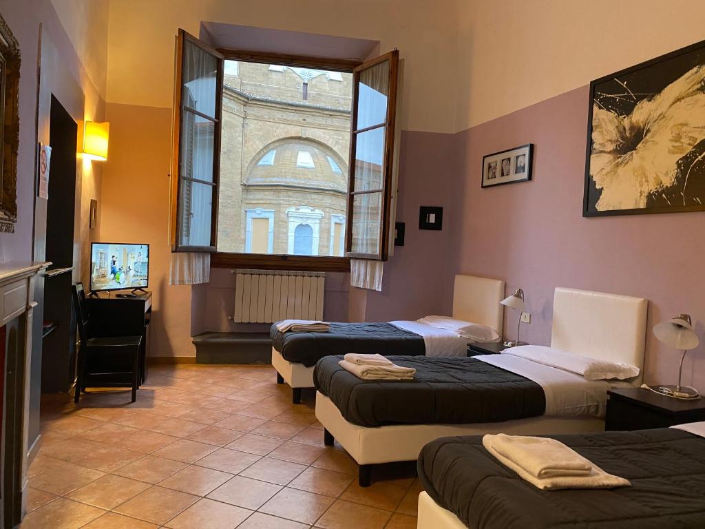 um quarto com três camas e uma janela em Emerald Palace em Florença