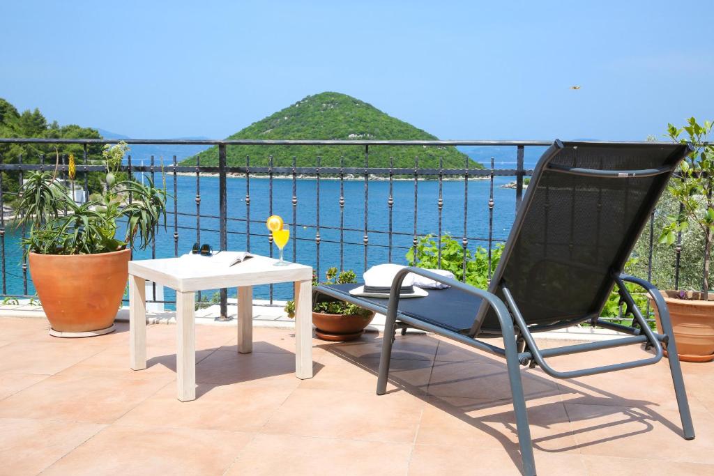 una silla y una mesa en un balcón con vistas al agua en Spacious apartment Lucia, en Prožura