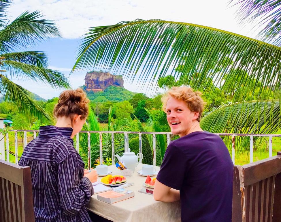 een man en een vrouw aan een tafel bij Lakmini Lodge Sigiriya in Sigiriya