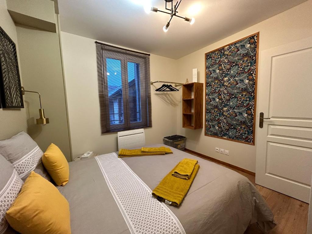 a bedroom with a bed with a yellow blanket on it at Ay central in Ay