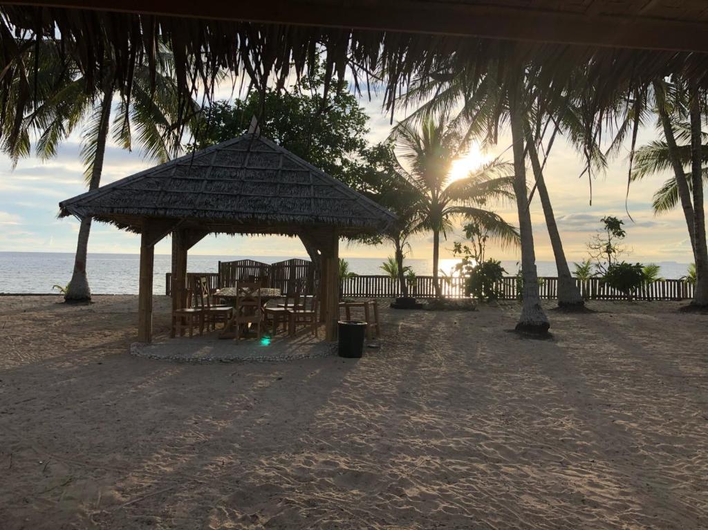 pawilon na plaży ze słońcem w tle w obiekcie Isla Mystica Beach Resort w mieście San Juan