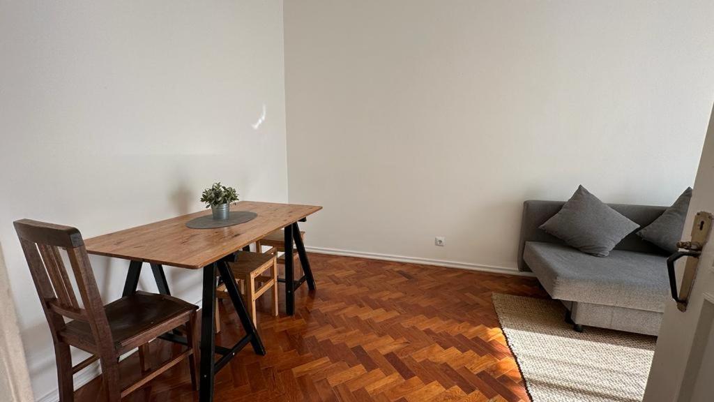 a living room with a wooden table and a couch at Coral Apartment in Lisbon