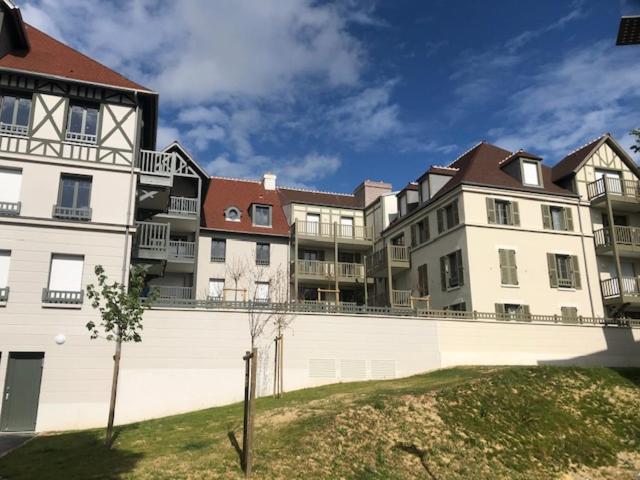 un grand immeuble d'appartements avec un mur blanc dans l'établissement charmant appartement en plein coeur de Trouville, à Trouville-sur-Mer