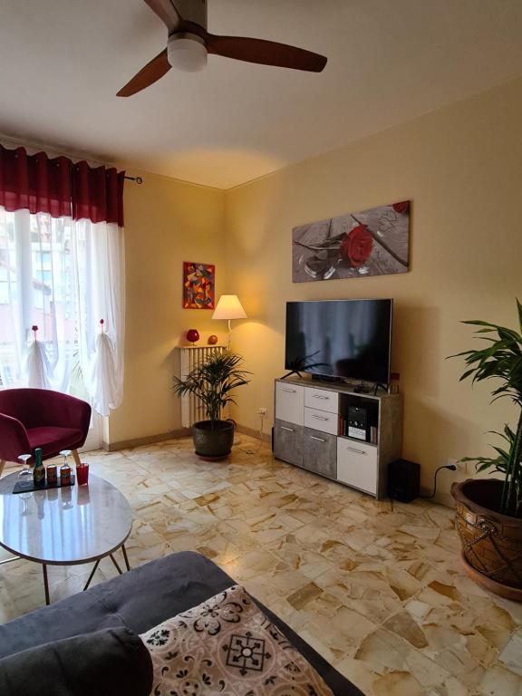 a living room with a ceiling fan and a tv at Casa dell amore 2 in Sanremo