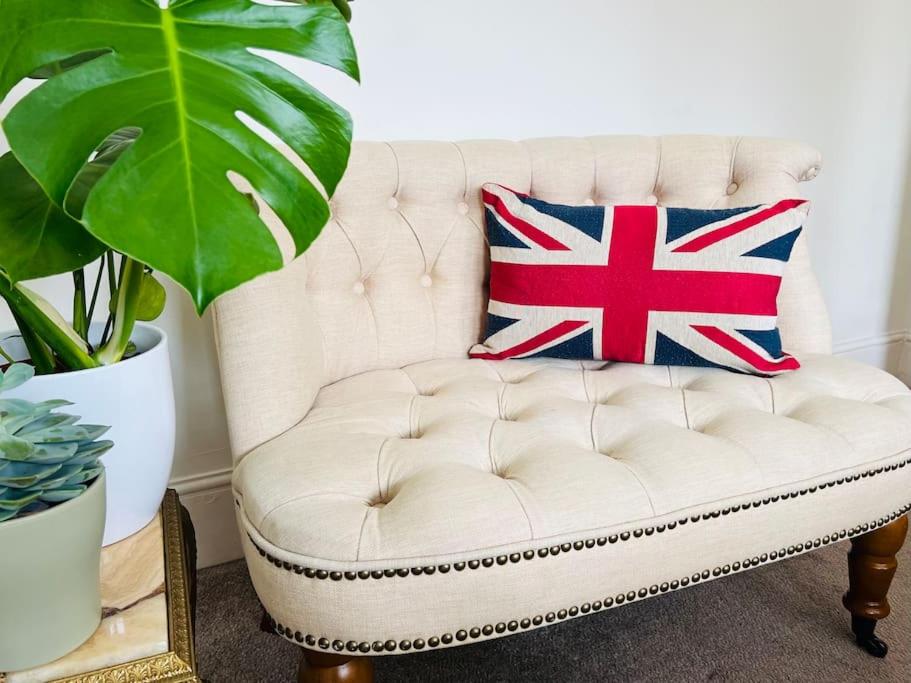 a white couch with a pillow with the british flag at Liverpool Victorian Townhouse - 3 Bedrooms in Liverpool