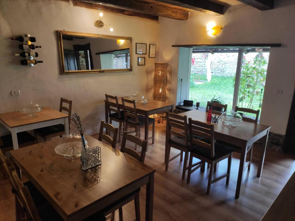 Casa Marta في Bărcuţ: غرفة طعام مع طاولات وكراسي ومرآة