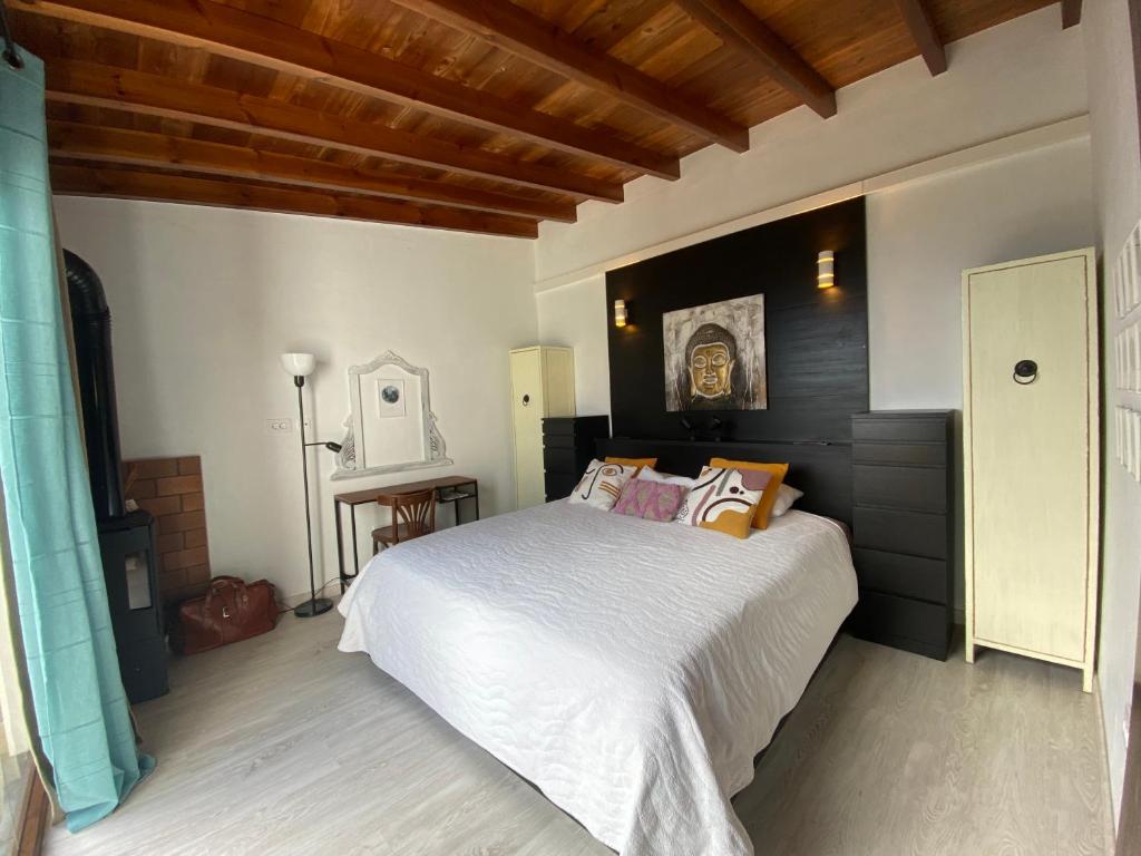a bedroom with a large white bed and wooden ceilings at La Cuadra de Pascuala in Tajace de Abajo