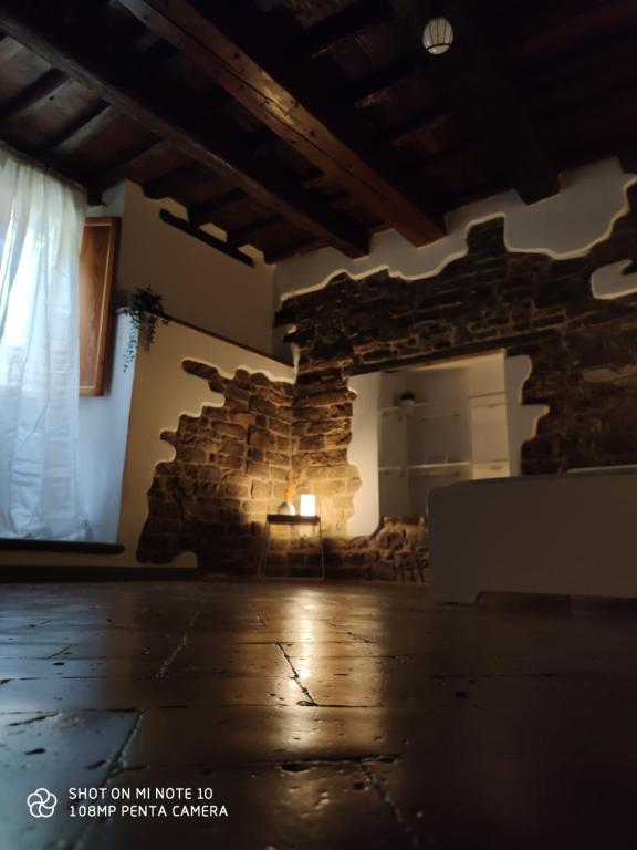 uma sala com uma parede de pedra e uma mesa com uma vela em Dante's Room dei Cerchi em Florença