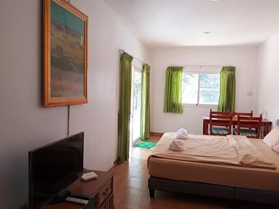 a bedroom with a bed and a flat screen tv at บ้านสวนแม่น้ำ-บ้านพูลวิลล่า in Ban Kao